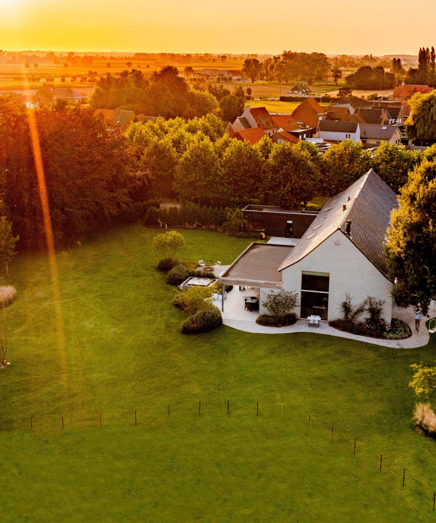 Uitgestrekte landschapstuin in Koekelare met cortenstaal omheining en weelderige beplanting.