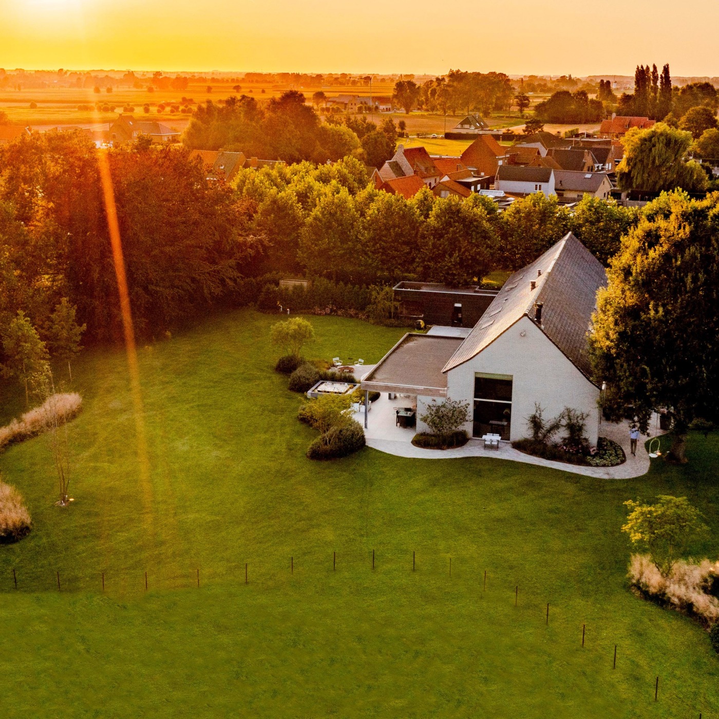 Uitgestrekte landschapstuin in Koekelare met cortenstaal omheining en weelderige beplanting.